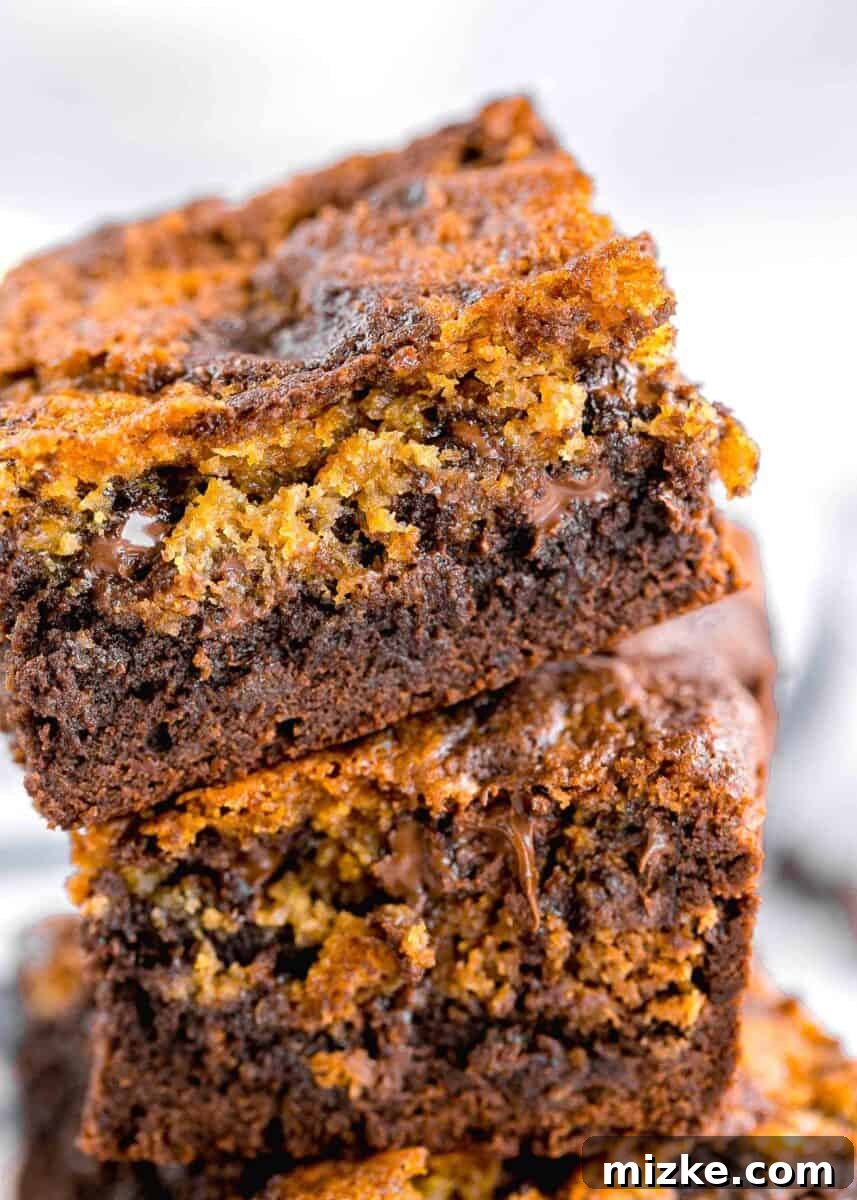 Brownie Cookie Fusion 11 A stack of perfectly baked brookies, showing off their distinct layers and tempting textures, rests on a white surface.