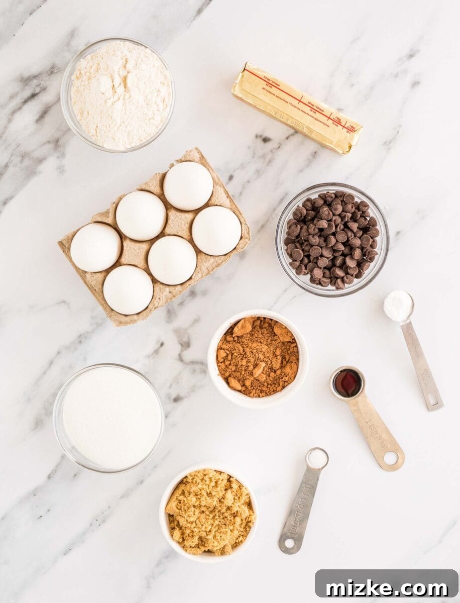 Brownie Cookie Fusion 3 All the fresh ingredients needed for baking homemade brookies are neatly arranged on a clean marble countertop, ready for preparation.