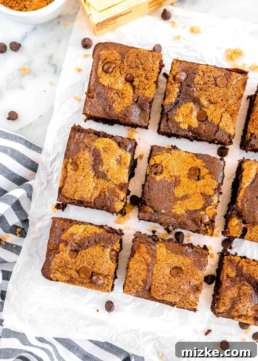 Brownie Cookie Fusion 10 Nine perfectly sliced, square brookies are arranged on a sheet of parchment paper, showcasing their distinct brownie and cookie layers.