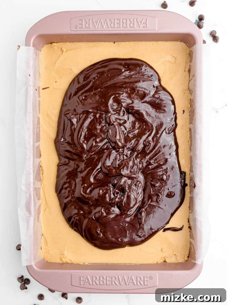 Buckeye Bliss Brownies 11 chocolate has been added on top of a peanut butter layer