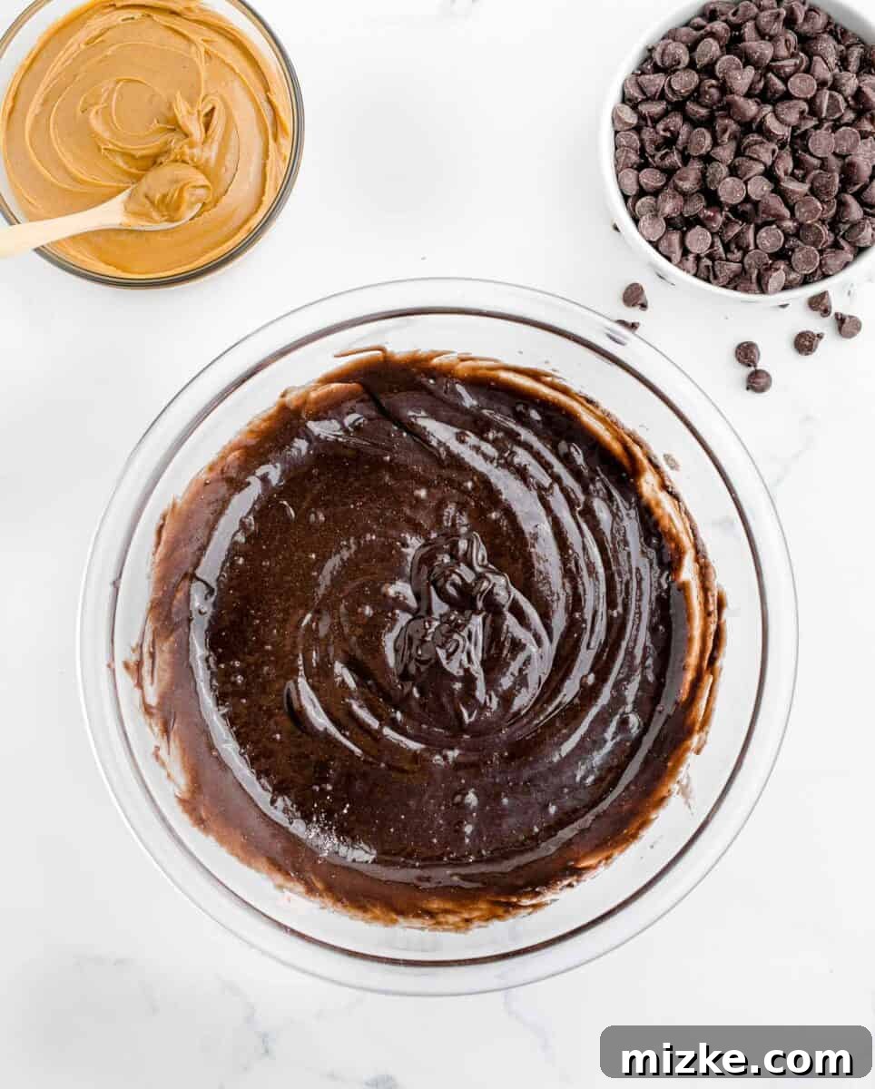 Buckeye Bliss Brownies 5 brownie batter is placed next to some peanut butter and chocolate chips