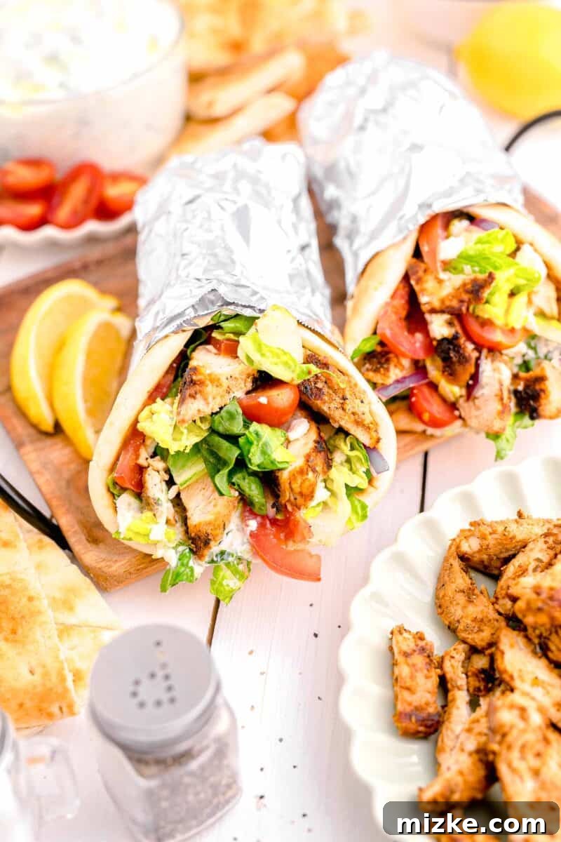 Mediterranean Chicken Wraps 2 two gyros are placed next to a lemon slice.