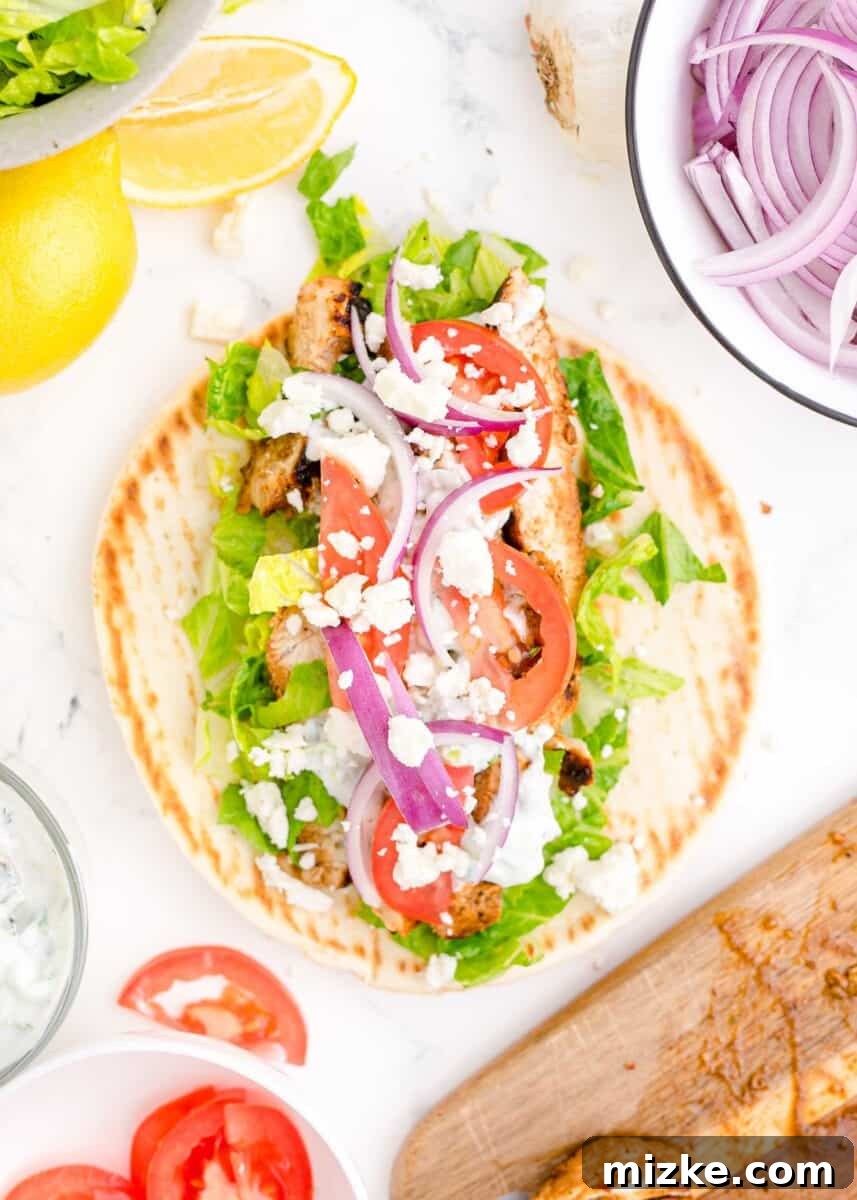 Mediterranean Chicken Wraps 11 veggies, chicken, and tzatziki are placed on top of an open gyro.