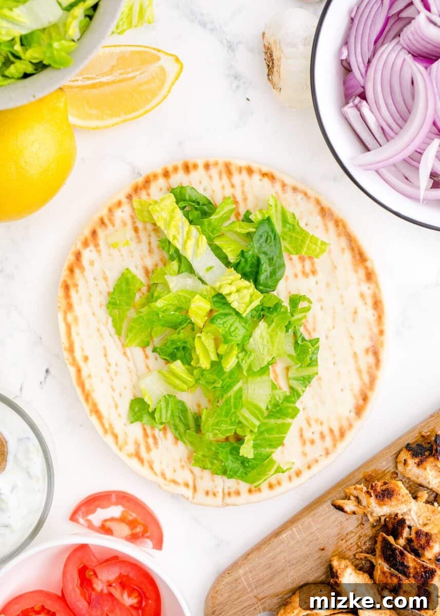 Mediterranean Chicken Wraps 8 lettuce is placed on top of an open gyro.