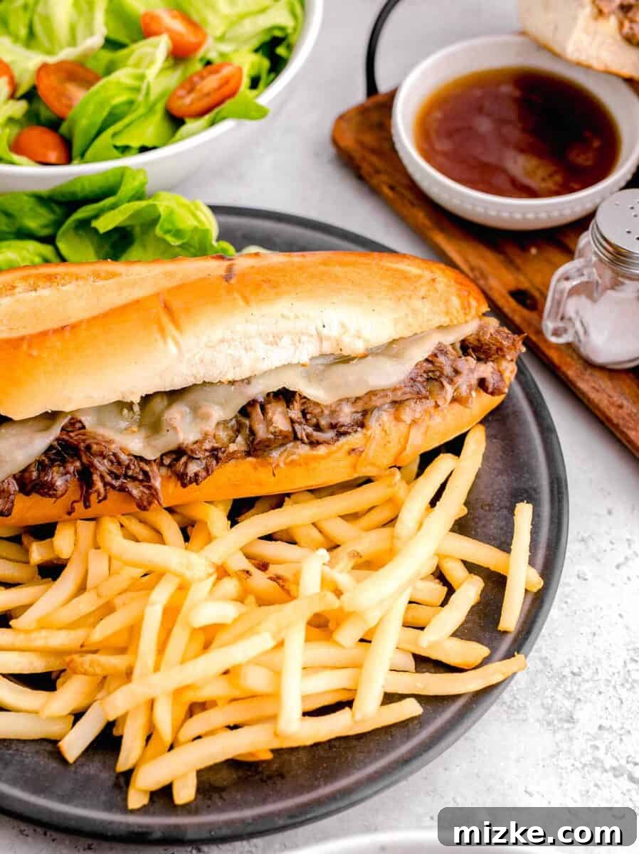 Effortless Slow Cooker French Dip Perfection 2 Crispy golden fries served alongside a mouth-watering French Dip sandwich, ready for dipping.