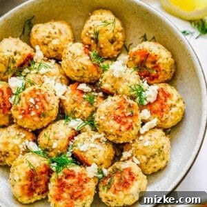Greek chicken meatballs garnished with cheese and herbs.