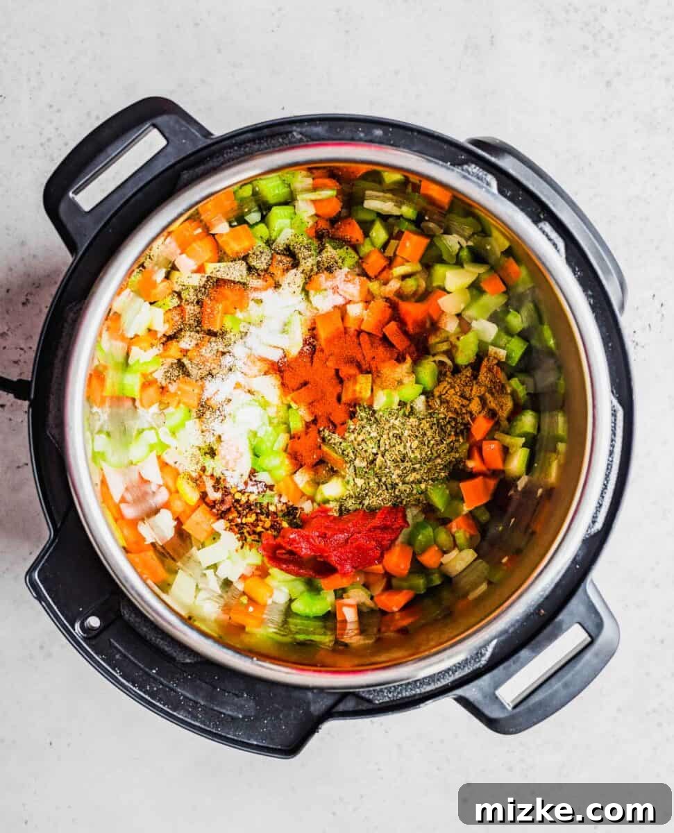 Aromatic seasonings are sprinkled over the cooked vegetables in an Instant Pot, ready to be stirred in.
