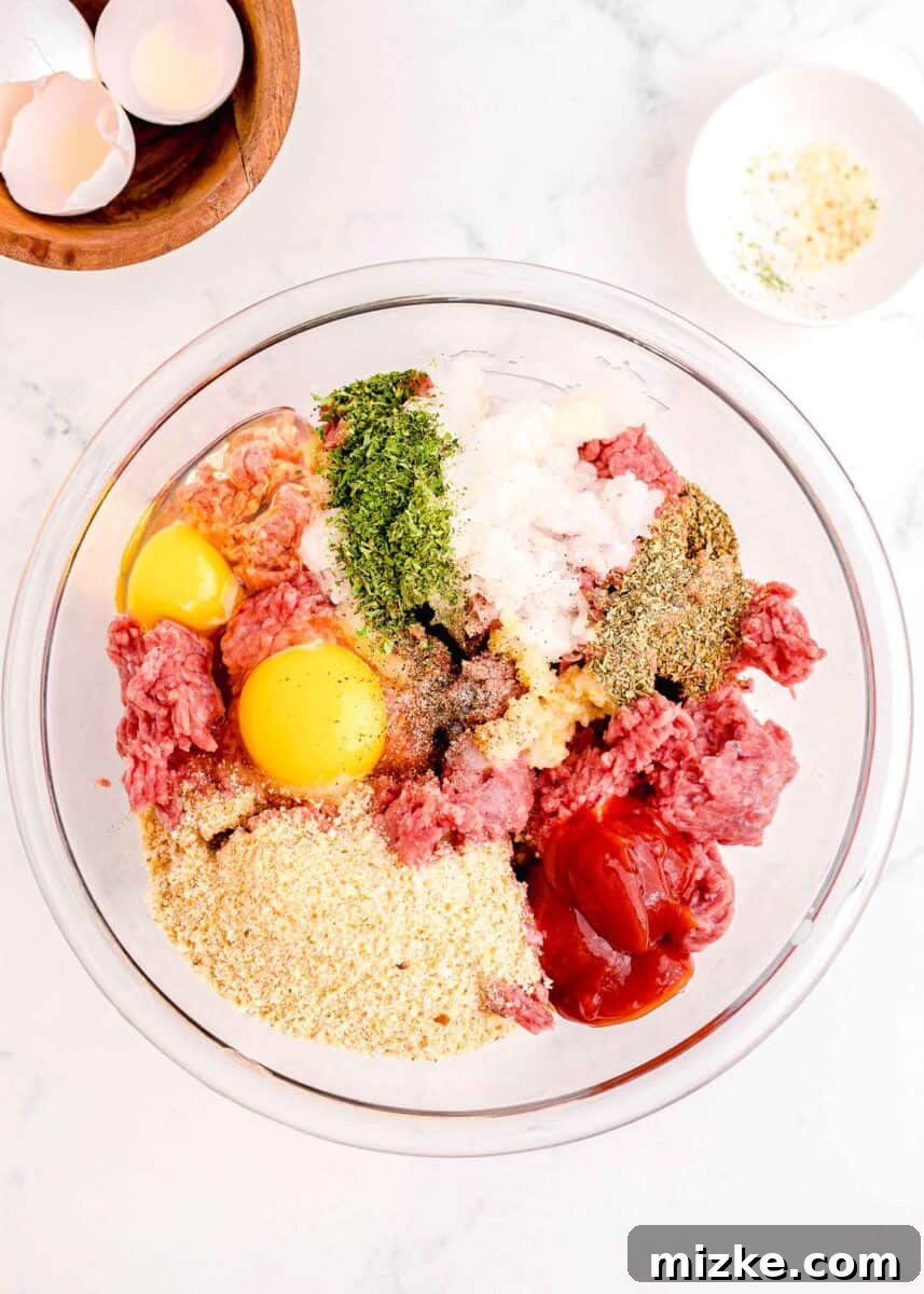 Perfect Instant Pot Meatloaf 4 All the raw meatloaf ingredients, including ground beef, diced onions, eggs, and various seasonings, are placed in a large glass mixing bowl, poised for gentle combination.