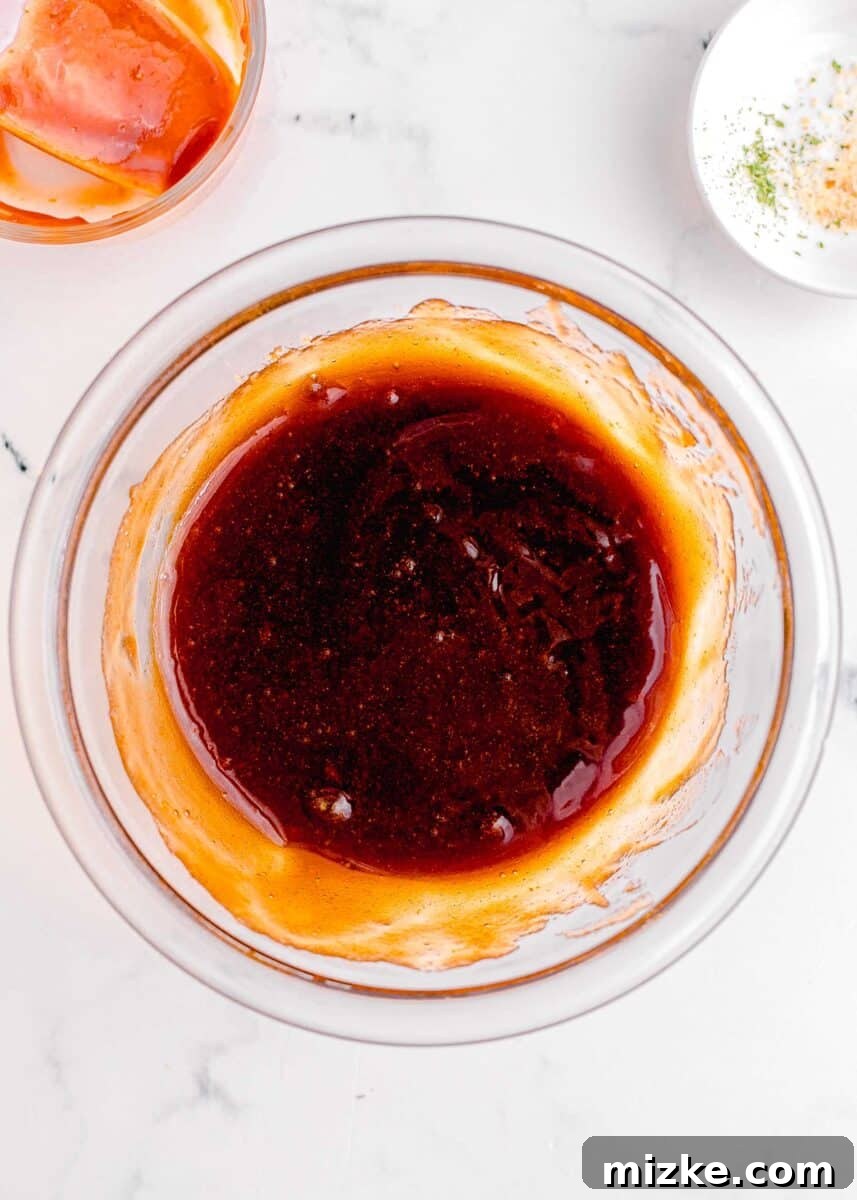 Perfect Instant Pot Meatloaf 9 The reddish-brown meatloaf glaze has been flawlessly mixed in a glass bowl, revealing its smooth, glossy texture and inviting color, ready to be applied.
