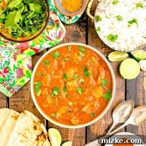 Effortless Crock-Pot Butter Chicken 11 A finished bowl of slow cooker butter chicken, generously garnished and ready to be served, showcasing its appetizing appearance.