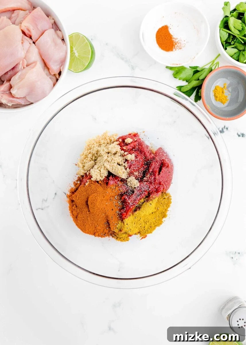 Effortless Crock-Pot Butter Chicken 6 A vibrant mix of garam masala, turmeric, brown sugar, salt, and black pepper, along with tomato paste, arranged in a mixing bowl, ready to be whisked into the creamy sauce base.