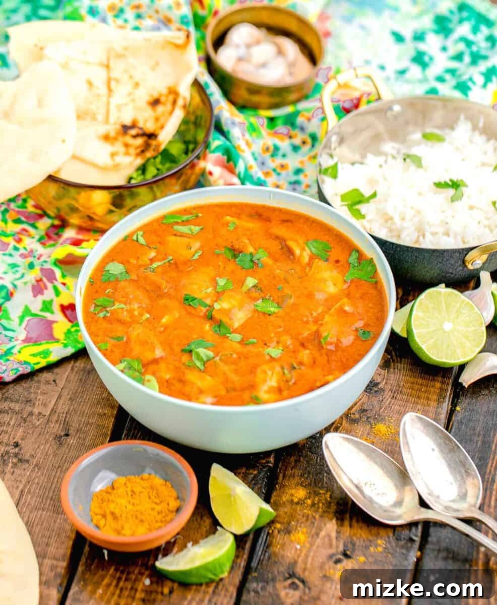 Effortless Crock-Pot Butter Chicken 10 A beautifully presented bowl of slow cooker butter chicken, generously garnished with fresh green herbs, creating an inviting and visually appealing meal, ready to be enjoyed.