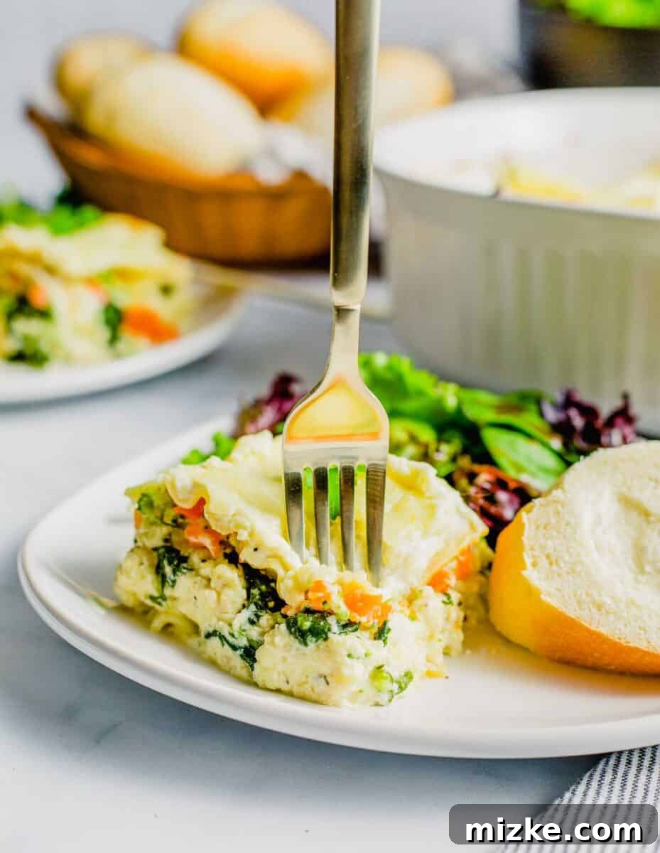 A fork piercing a perfect serving of white sauce lasagna on a plate, highlighting its layers of cheesy goodness.
