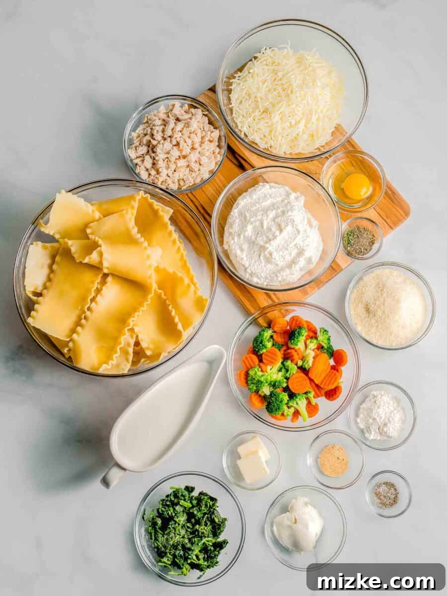 The array of fresh ingredients for white sauce lasagna, including various cheeses, vegetables, and chicken, neatly arranged on a kitchen countertop.