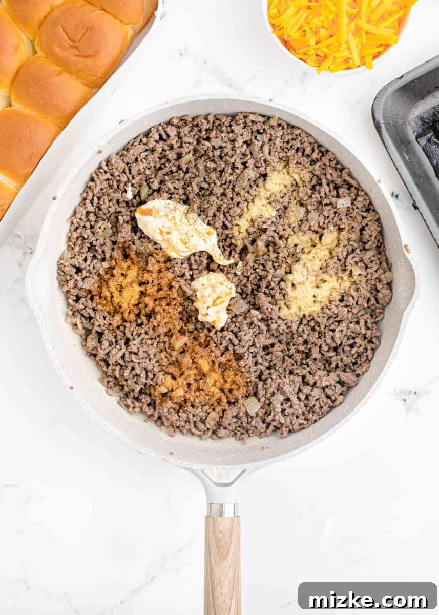 Pint-Sized Patty Perfection 4 Ground beef is actively cooking in a cast iron skillet, browning and releasing its juices.