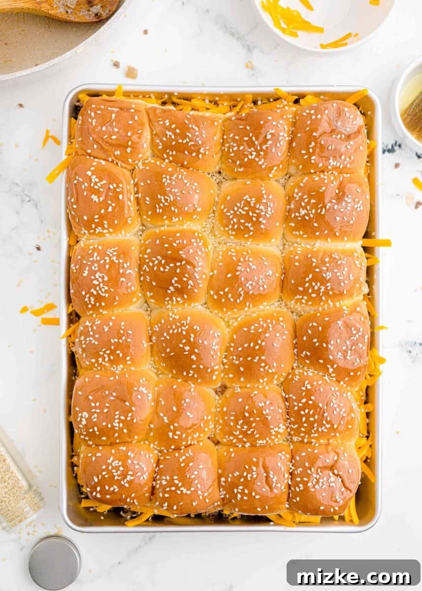 Pint-Sized Patty Perfection 9 The top halves of the slider buns have been brushed with butter and sprinkled with sesame seeds, ready for baking.