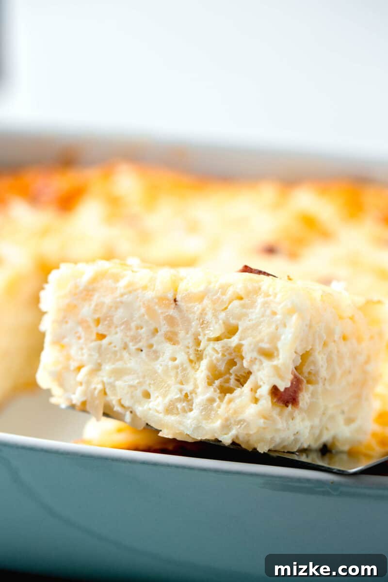 A mesmerizing close-up image of the inside of the baked egg white breakfast casserole, revealing its delightful layers of fluffy egg, savory diced sausage, and tender shredded potatoes, showcasing a perfect texture.