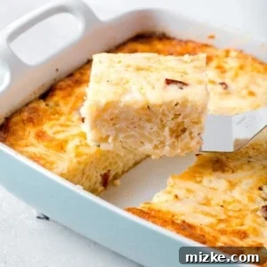 A slice of egg white breakfast casserole on a metal spatula being lifted up from the rest of the casserole