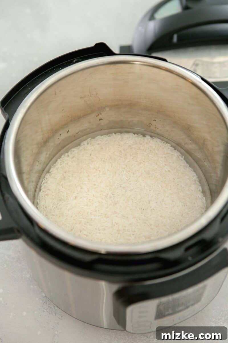Perfect Instant Pot Jasmine Rice 7 Measured water covering uncooked jasmine rice in the Instant Pot insert