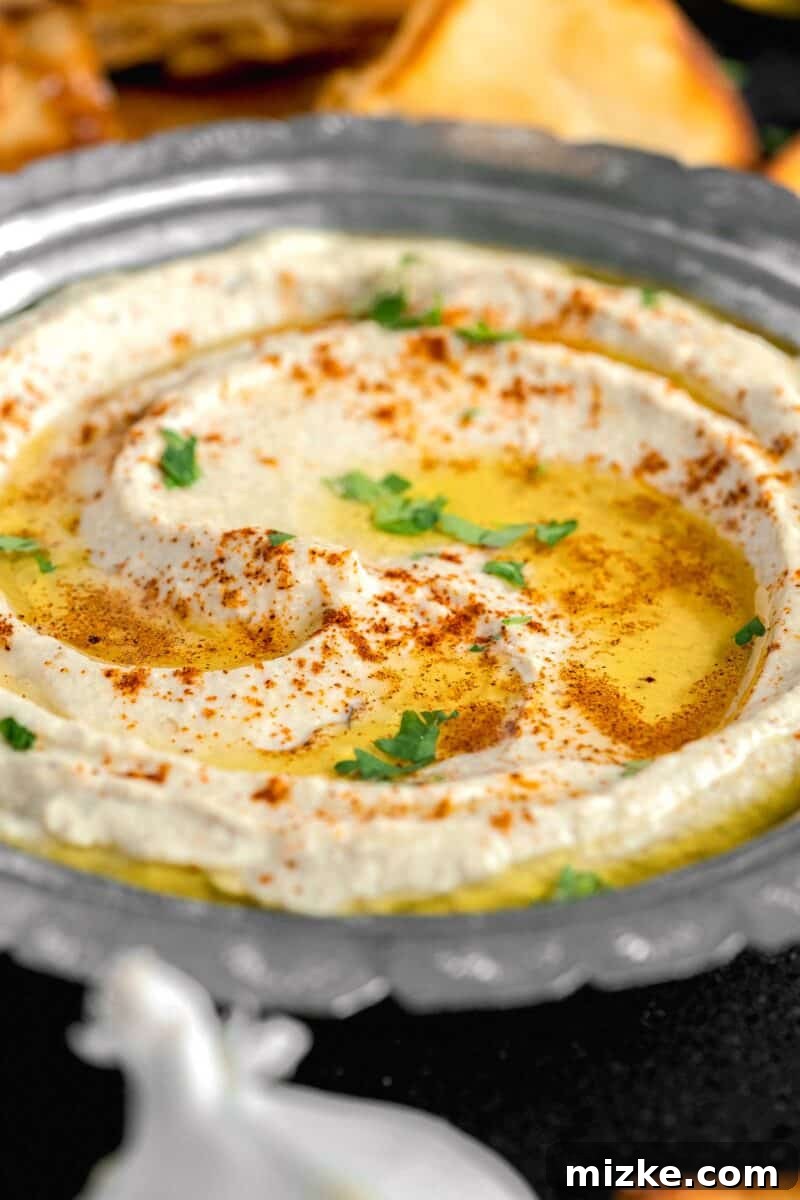 Smoky and Simple Baba Ganoush 11 A close-up shot of creamy Baba Ganoush in a bowl, with a generous swirl of golden olive oil pooled on top, ready to be served.