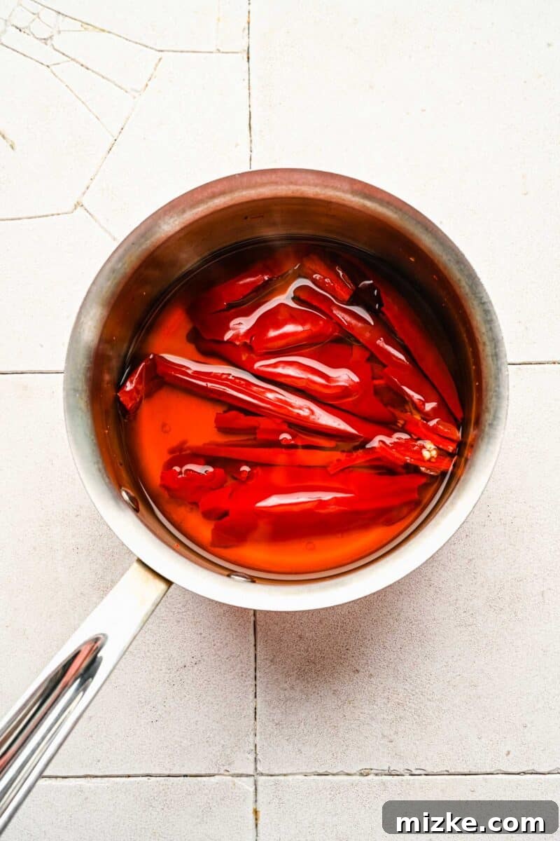 Bold Chipotle Guajillo Garlic Steak 6 Guajillo peppers rehydrating in simmering water in a pot.