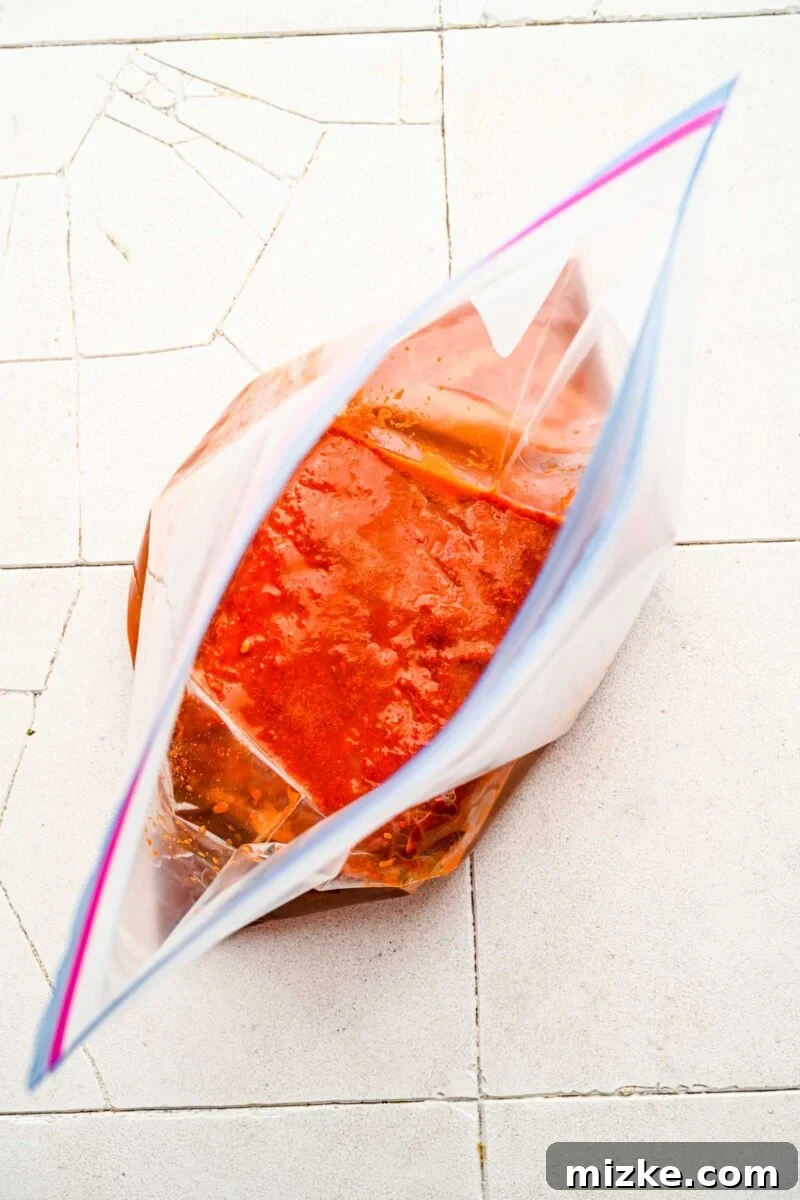 Bold Chipotle Guajillo Garlic Steak 9 Flank steak coated in garlic guajillo marinade inside a sealed plastic bag.