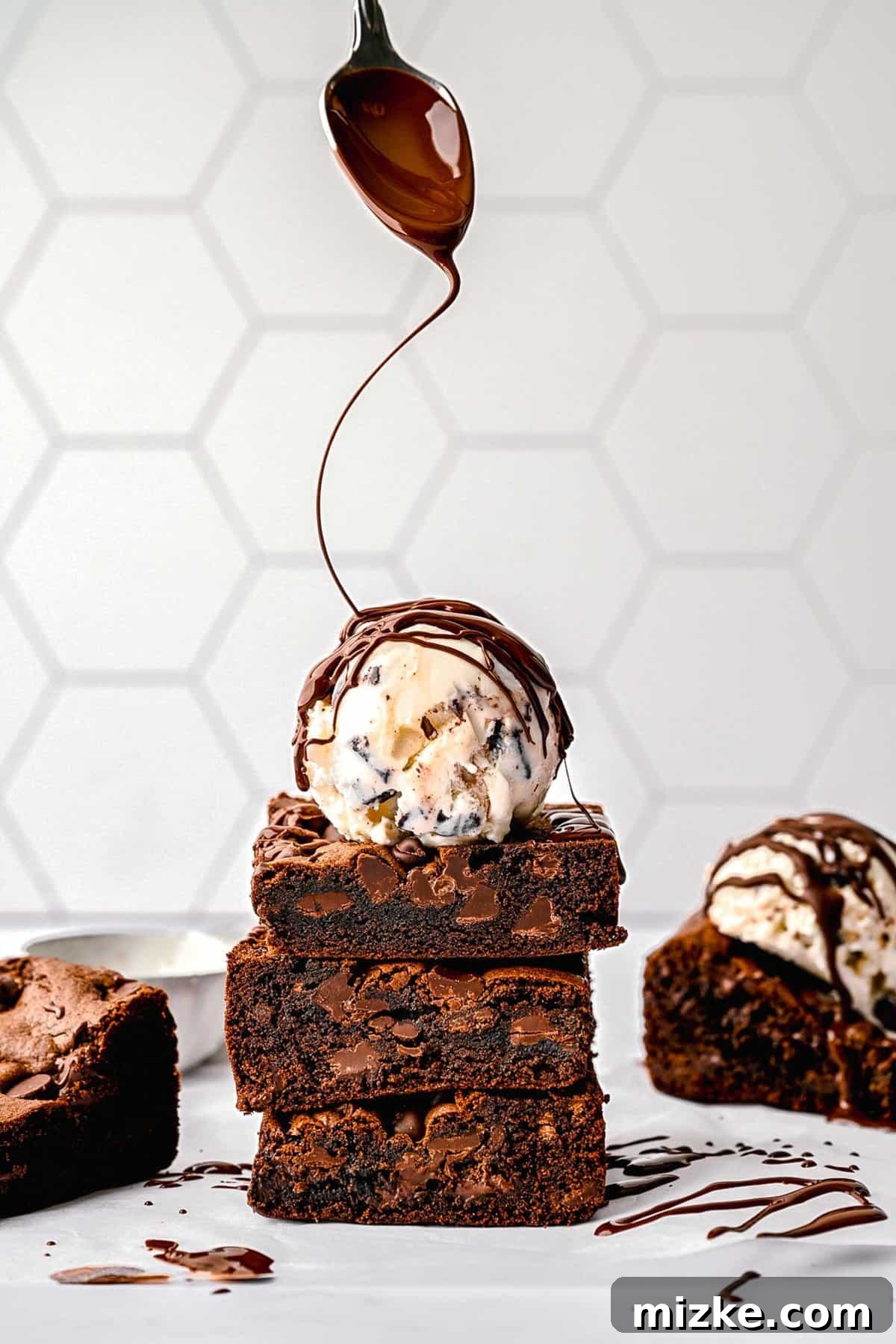 These cake mix brownies turn baking into a walk in the park. Made with 5 ingredients in 30 minutes, they're sure to become a new favorite. A stack of cake mix brownies with a scoop of vanilla ice cream on top, drizzled with chocolate sauce.