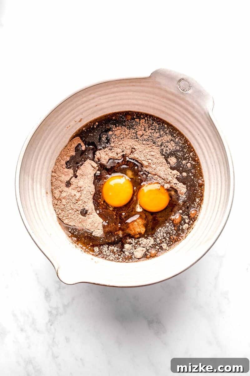 These cake mix brownies turn baking into a walk in the park. Made with 5 ingredients in 30 minutes, they're sure to become a new favorite. Combining chocolate cake mix, oil, eggs, and vanilla extract in a large mixing bowl.