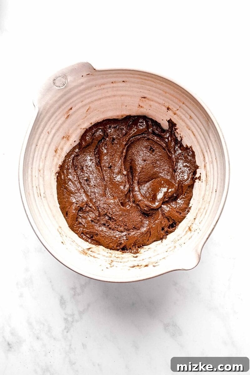 These cake mix brownies turn baking into a walk in the park. Made with 5 ingredients in 30 minutes, they're sure to become a new favorite. Smooth, thick brownie batter in a mixing bowl, ready for chocolate chips.