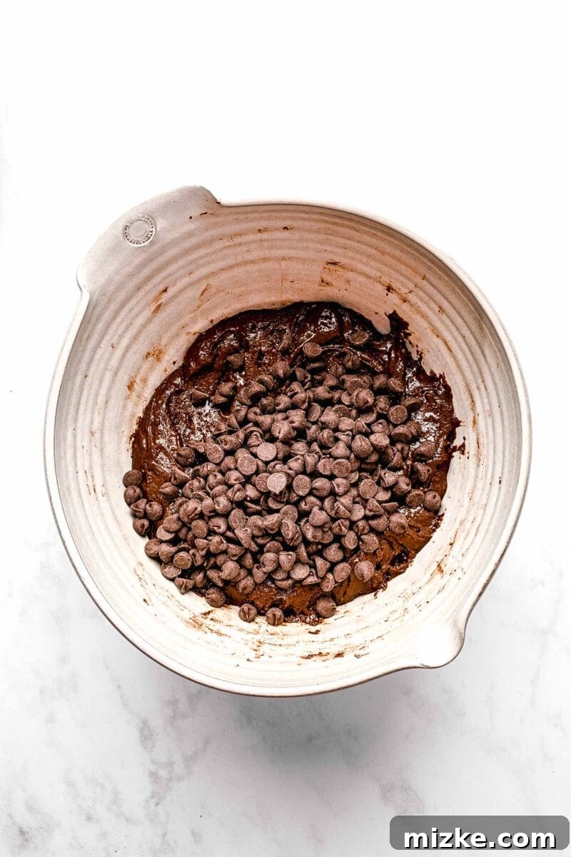 These cake mix brownies turn baking into a walk in the park. Made with 5 ingredients in 30 minutes, they're sure to become a new favorite. Adding a generous amount of semi-sweet chocolate chips to the brownie batter.