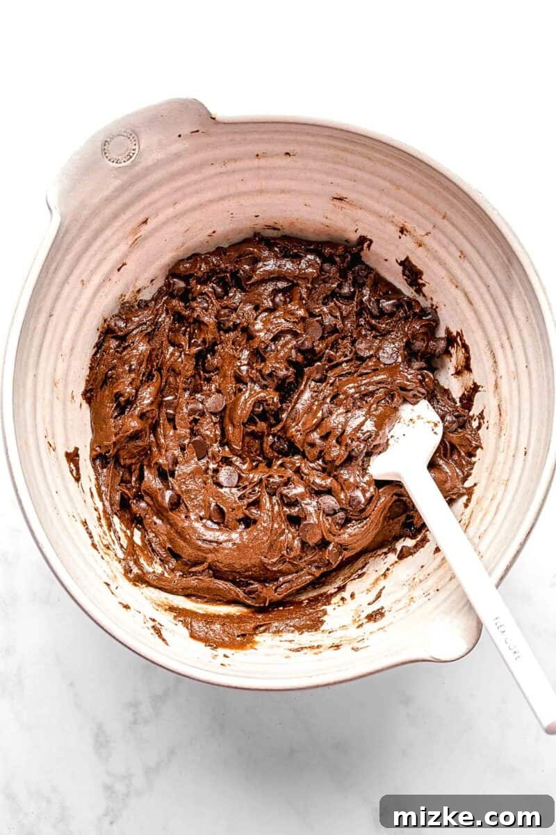 These cake mix brownies turn baking into a walk in the park. Made with 5 ingredients in 30 minutes, they're sure to become a new favorite. Gently mixing chocolate chips into the brownie batter with a spatula.