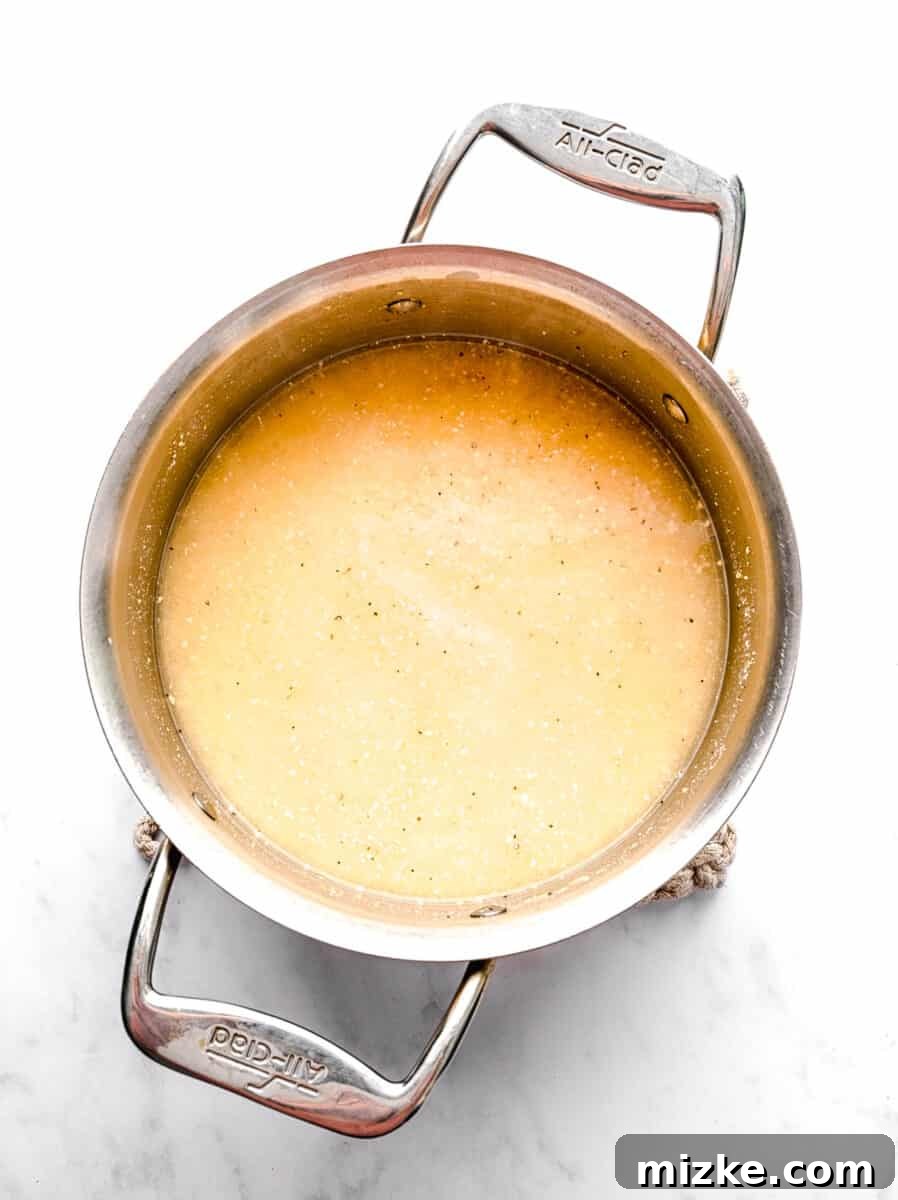 These polenta fries are made from cheesy polenta cut into strips, brushed with olive oil, and baked to crispy golden brown. Polenta and water in a pot.