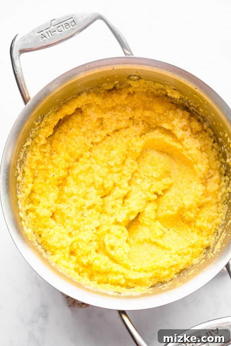 These polenta fries are made from cheesy polenta cut into strips, brushed with olive oil, and baked to crispy golden brown. Cooked polenta in a pot.