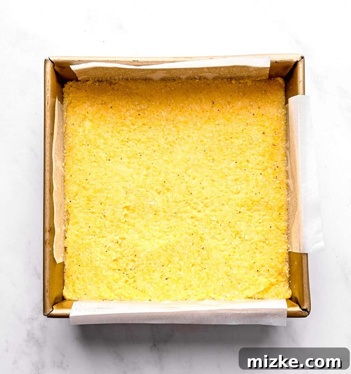 These polenta fries are made from cheesy polenta cut into strips, brushed with olive oil, and baked to crispy golden brown. Chilled polenta in a baking pan.