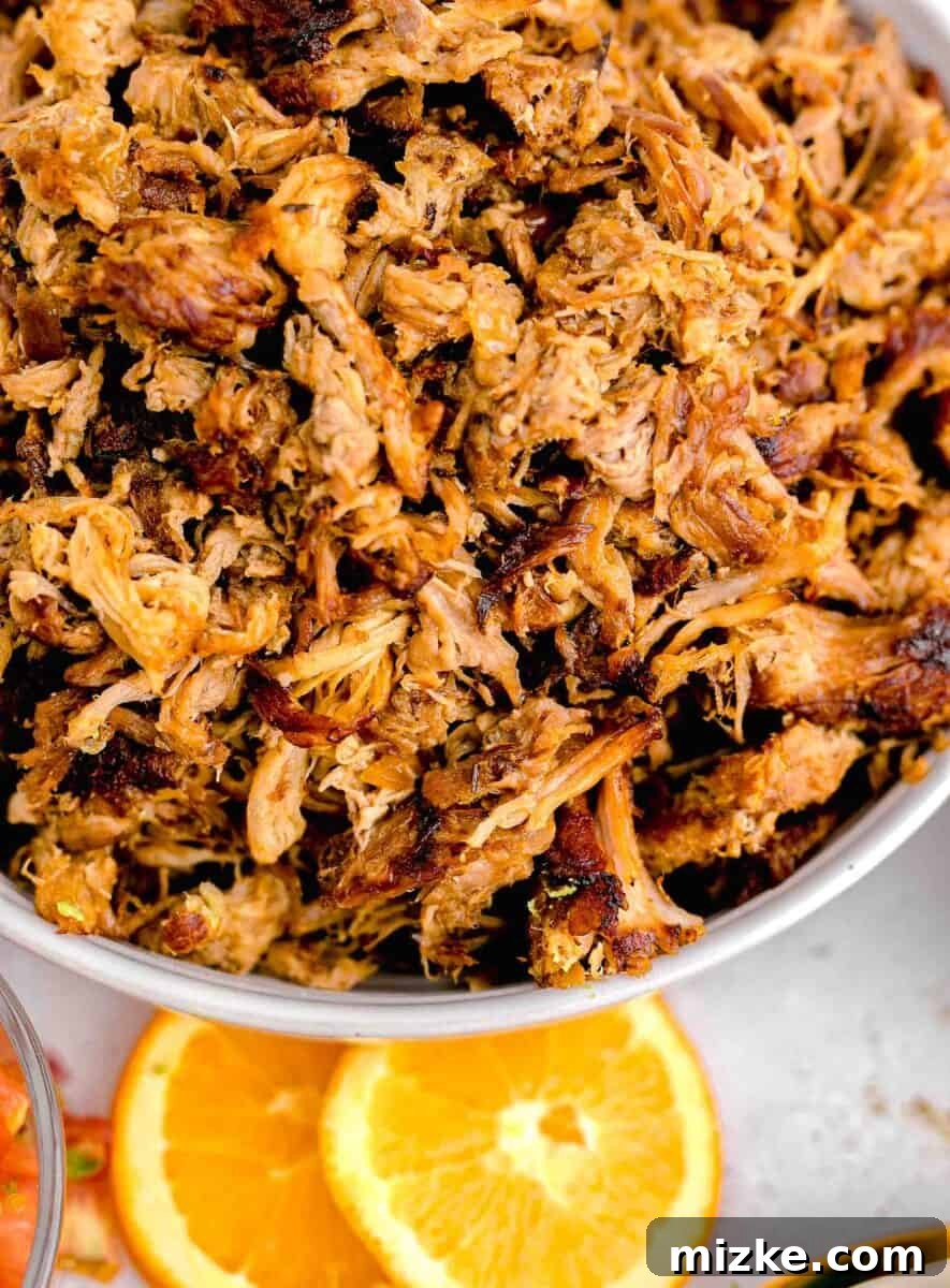 Melt-Away Slow Cooker Pork Carnitas 13 A pristine white bowl is generously filled with perfectly cooked and crispy pork carnitas.