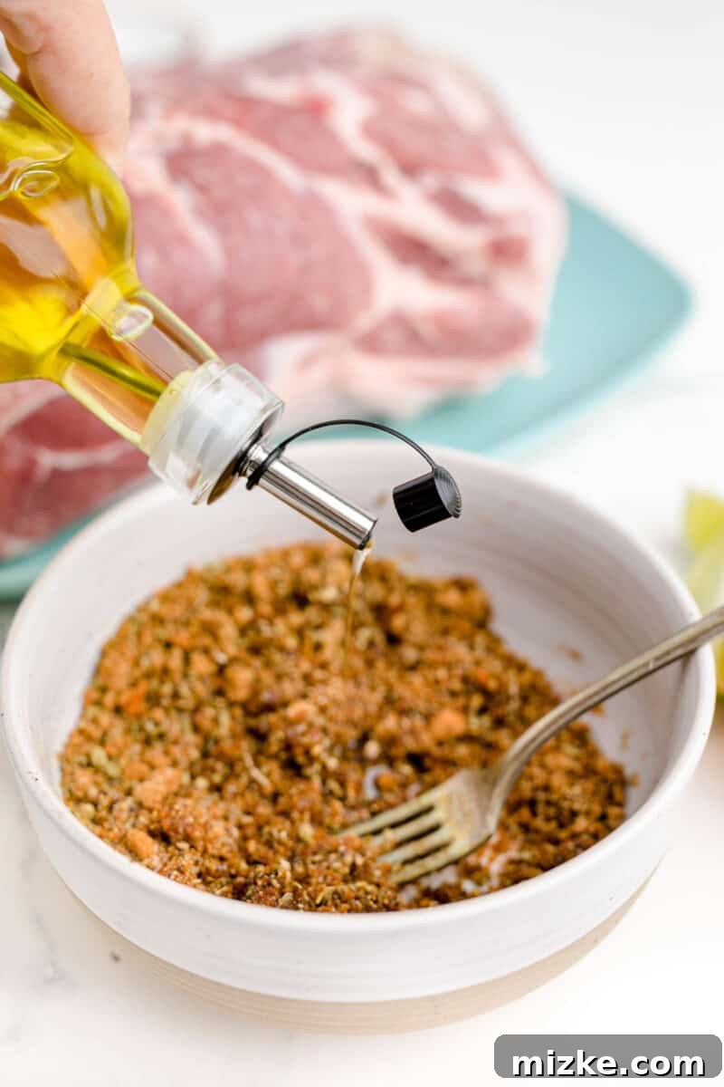 Melt-Away Slow Cooker Pork Carnitas 5 Olive oil is being drizzled into a bowl of dry seasonings, preparing a flavorful rub.
