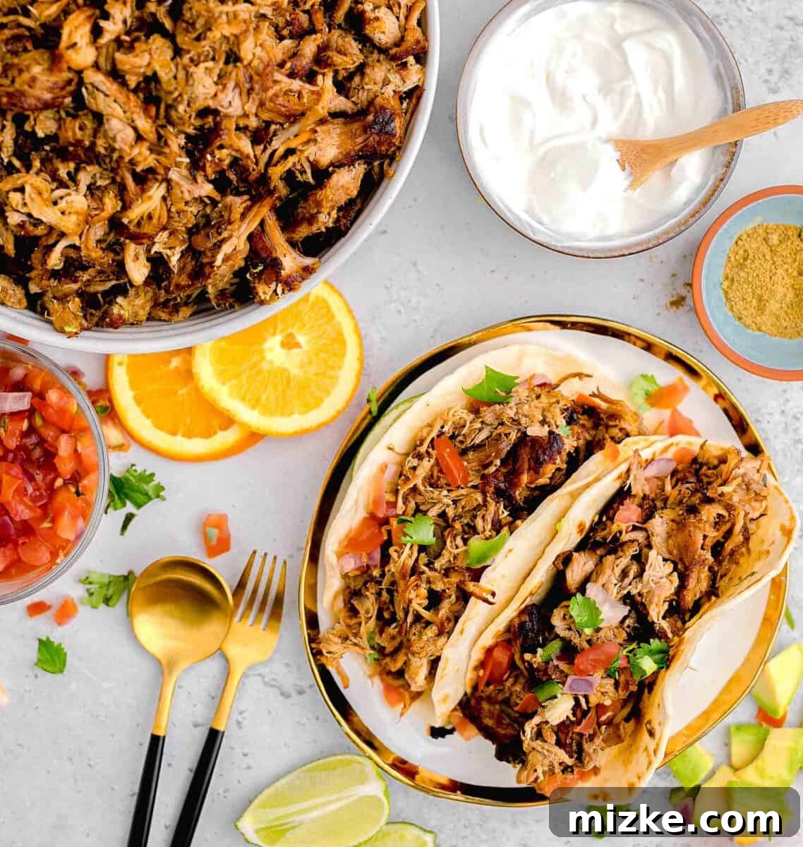 Two perfectly assembled pork carnitas street tacos are placed next to a rustic skillet brimming with flavorful carnitas meat, ready for serving.