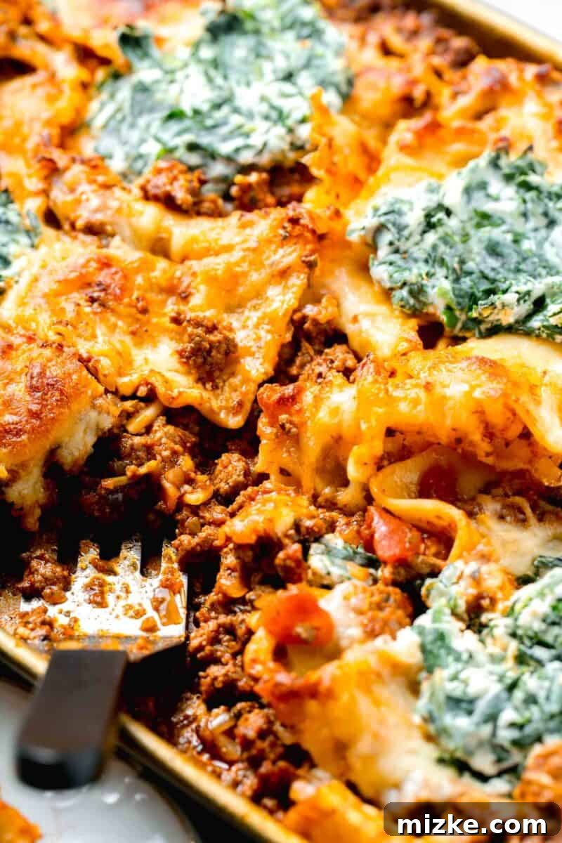 Effortless Sheet Pan Lasagna 14 sheet pan lasagna with a metal spatula in the center, ready to be served