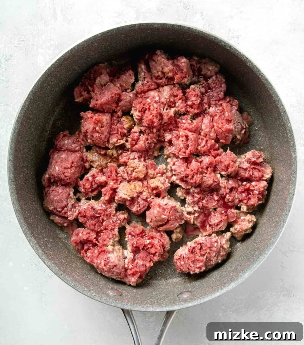 Effortless Sheet Pan Lasagna 6 ground beef being cooked in a nonstick skillet