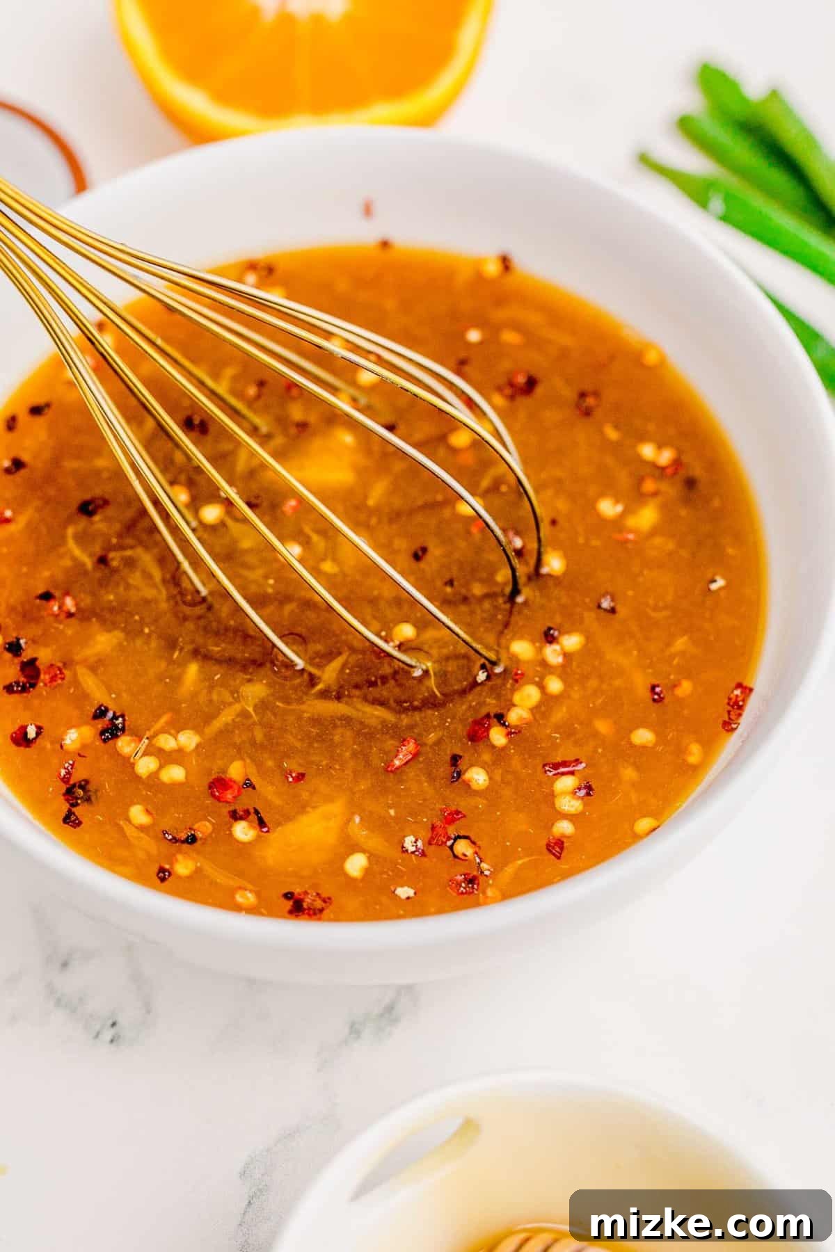 The perfect homemade orange chicken sauce, ready to elevate your dish. A bowl of freshly prepared orange chicken sauce, showcasing its rich color and smooth texture.