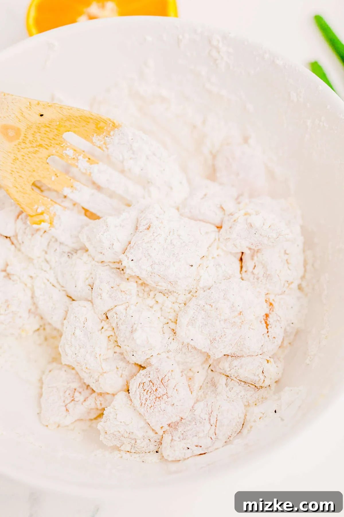 Perfectly breaded chicken awaiting its crispy transformation. A plate filled with evenly breaded raw chicken pieces, ready for frying.