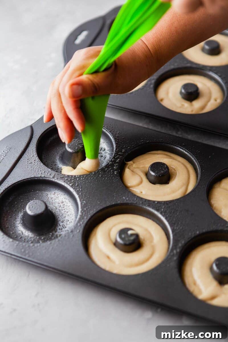 Perfectly Baked Vanilla Delights 7 Donut tins are uniformly filled with batter, ready to be baked to golden perfection.