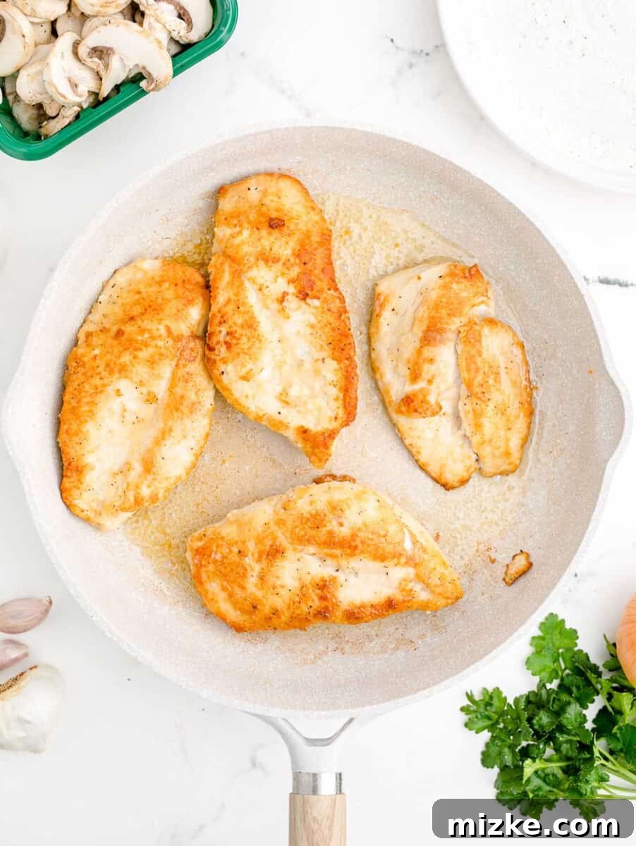 Simple Weeknight Chicken Marsala 7 A close-up shot of several chicken breasts perfectly seared to a golden-brown crisp in a skillet.