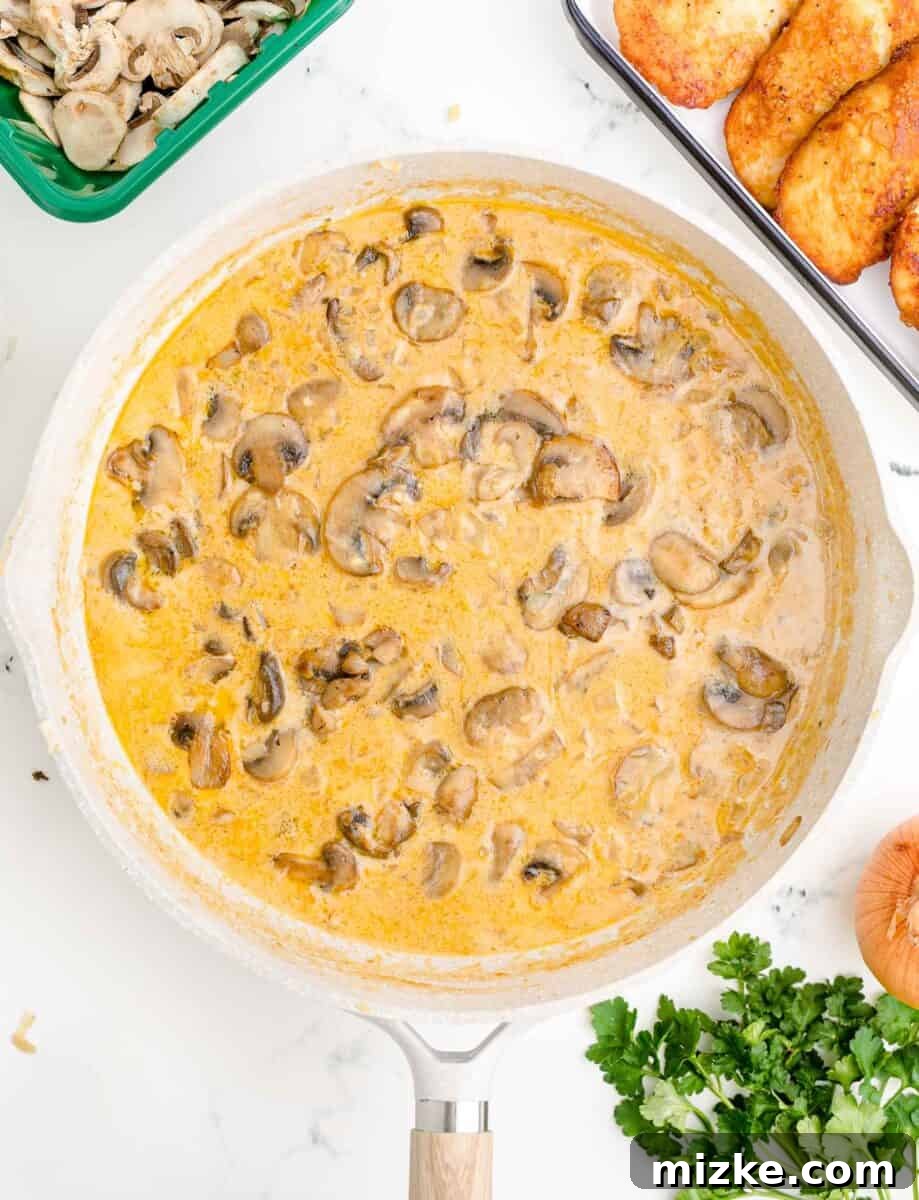 Simple Weeknight Chicken Marsala 9 A creamy, rich Marsala sauce with tender mushrooms simmers gently in a white skillet.