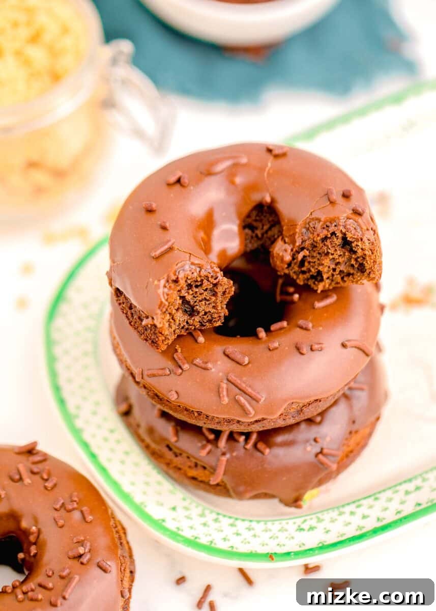 A chocolate donut that has been bitten into, revealing its moist, perfectly cooked interior.