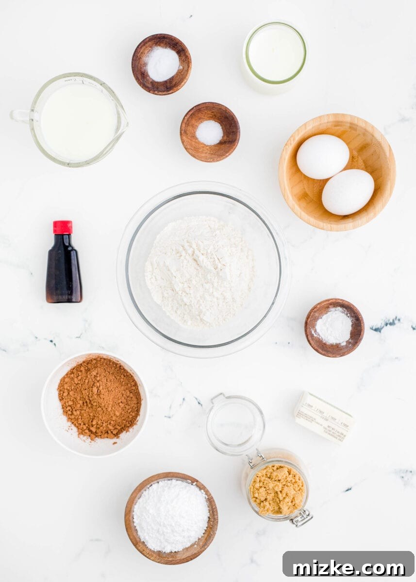 Fresh ingredients for baked chocolate donuts laid out neatly on a white kitchen counter, ready for preparation.