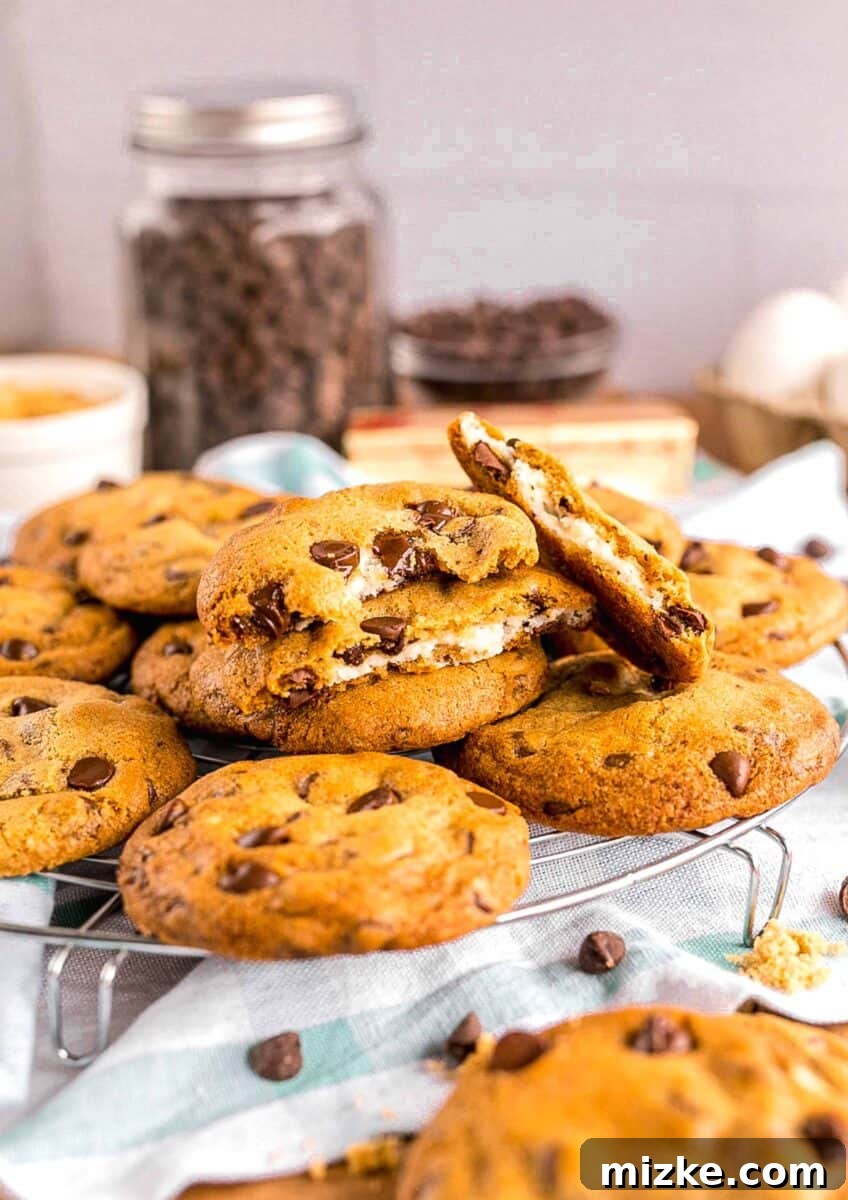 Decadent Cheesecake-Stuffed Chocolate Chip Cookies 2 several cheesecake stuffed chocolate chip cookies have been halved to reveal a cheesecake center, showcasing the creamy filling.