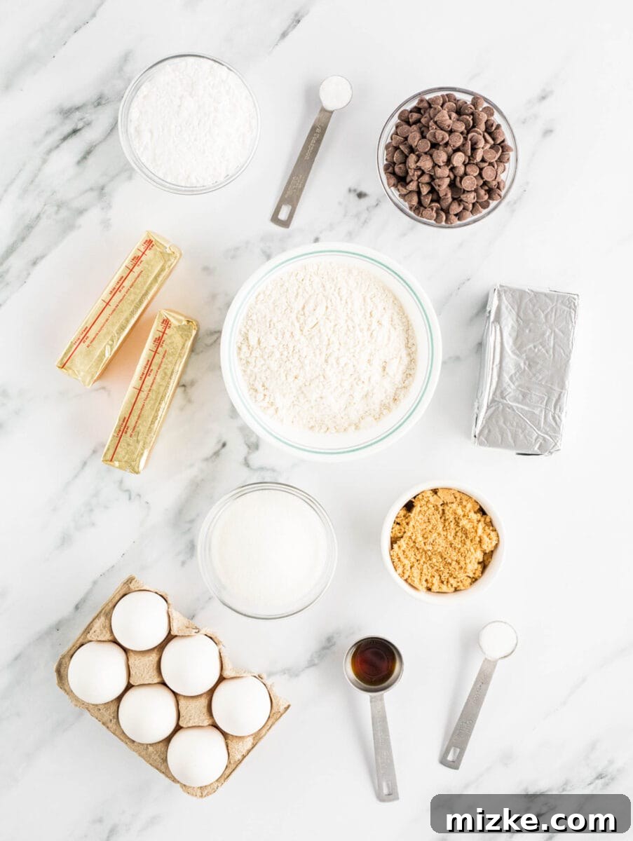 Decadent Cheesecake-Stuffed Chocolate Chip Cookies 3 the ingredients for cheesecake stuffed cookies are placed on a white countertop, neatly arranged.