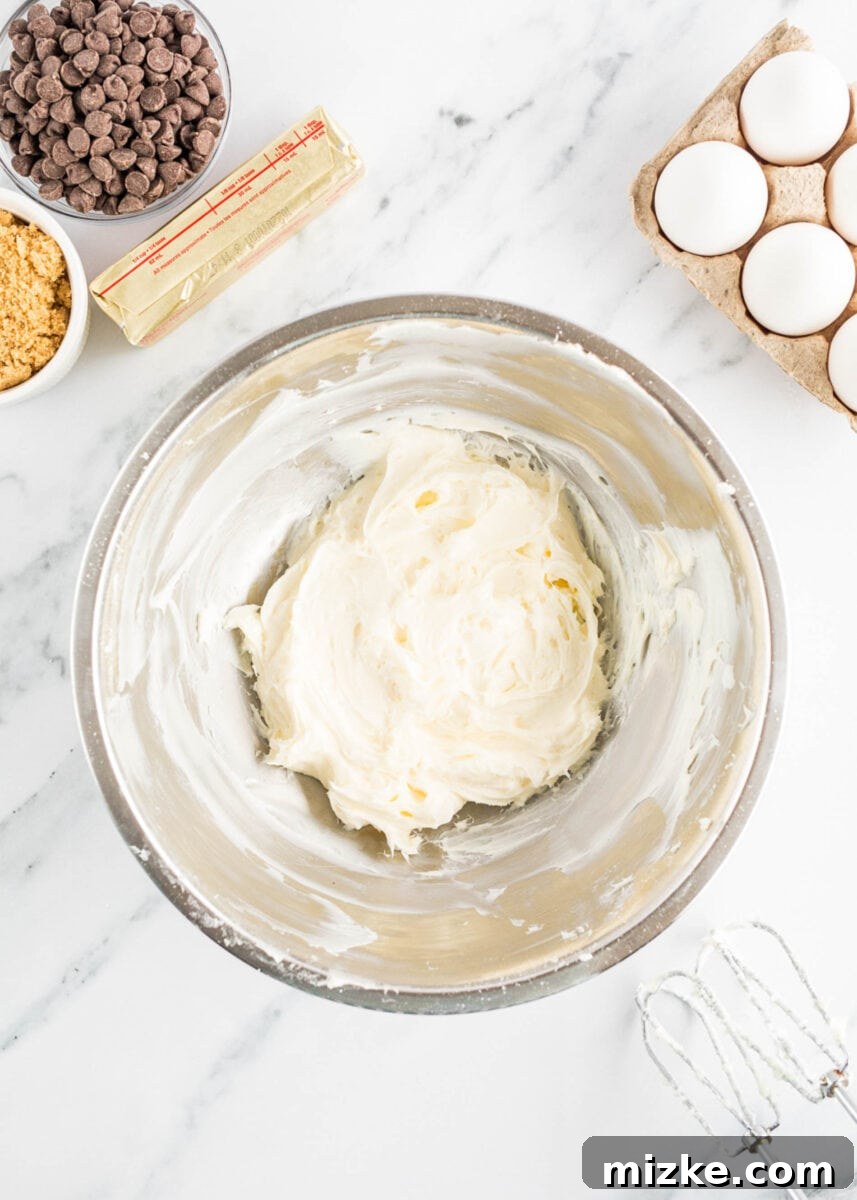 Decadent Cheesecake-Stuffed Chocolate Chip Cookies 5 cheesecake filling is being created in a mixing bowl, smooth and creamy.