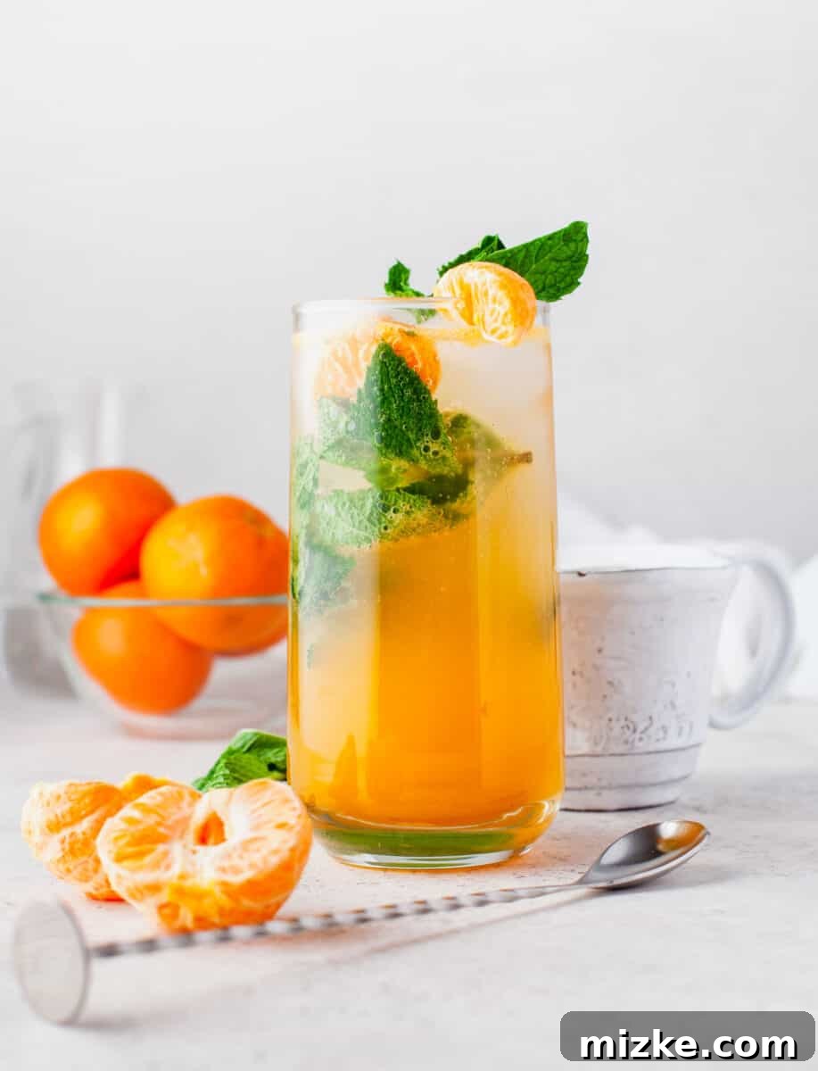 Sun-Kissed Mint Splash 7 A perfectly prepared glass of Orange Mojito, elegantly garnished with fresh mint leaves and orange slices, awaits enjoyment.
